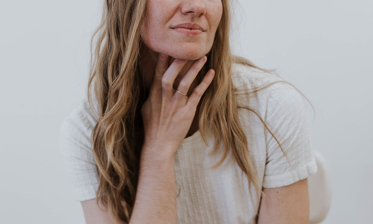 Blonde woman sitting with hand on chin